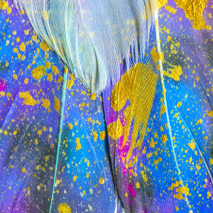 Splashes of gold paint on feathers.